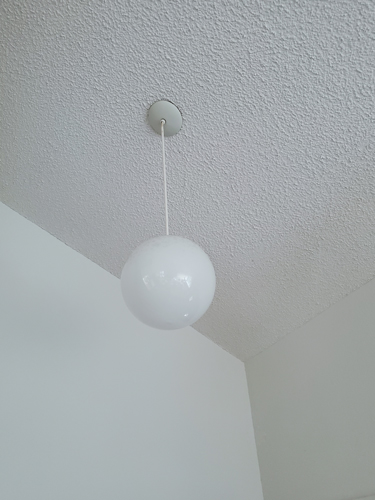 plain white globe pendant light hanging from the ceiling