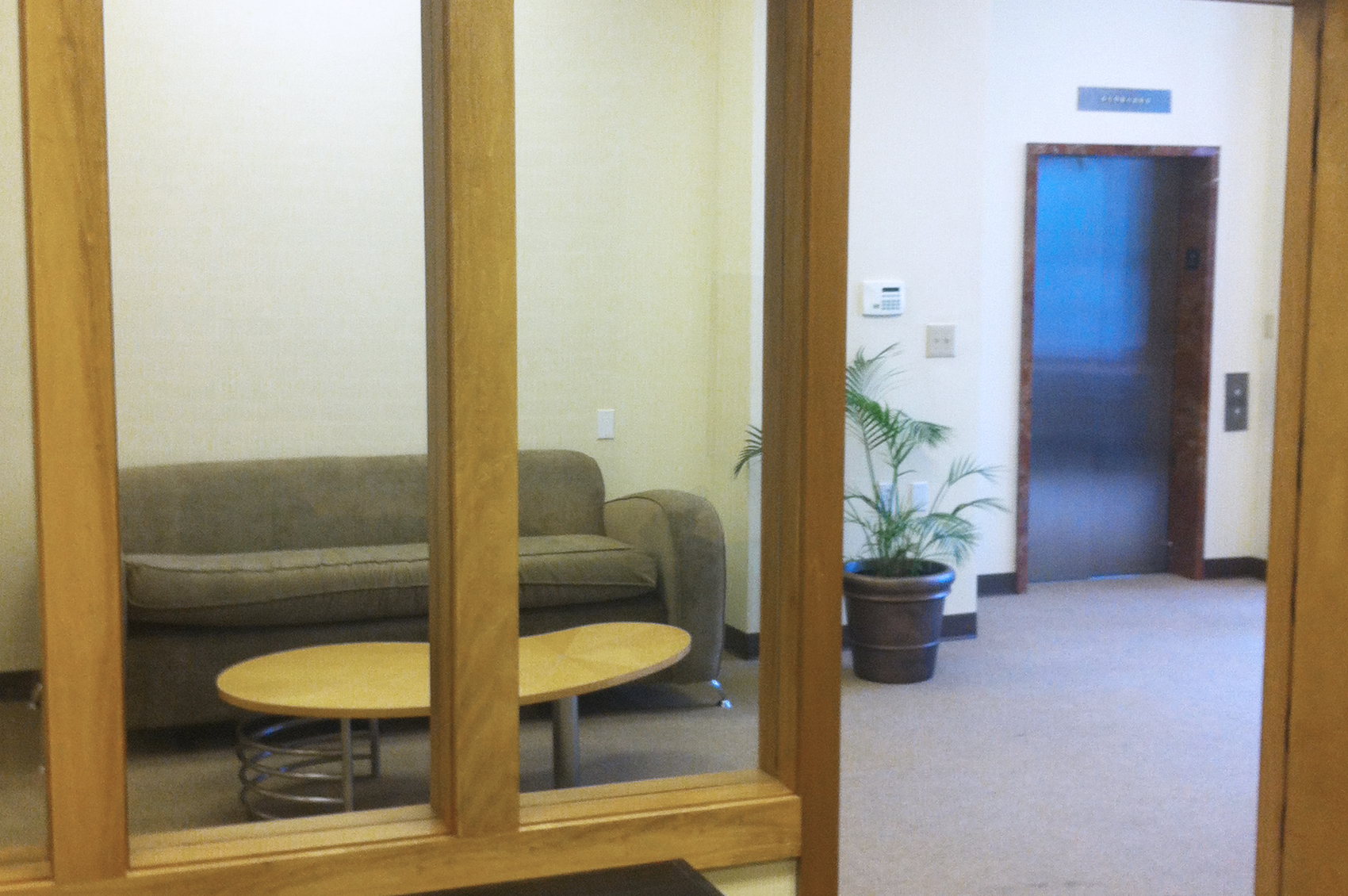 Office lobby area with couch and elevator door